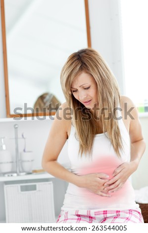 Suffering woman having a stomachache in her bathroom at home