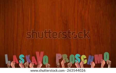 Hands holding up laskavo porschmo against wooden oak table