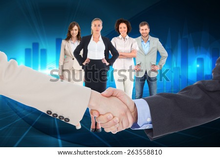 Smiling business people shaking hands while looking at the camera against blue bar chart graphic with light