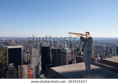 Businessman looking through telescope against city skyline