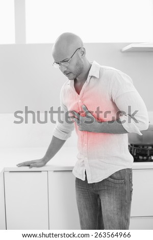 Casual young man suffering from chest pain standing at home