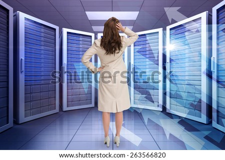 Businesswoman standing back to camera with hand on head against shiny arrows on black background