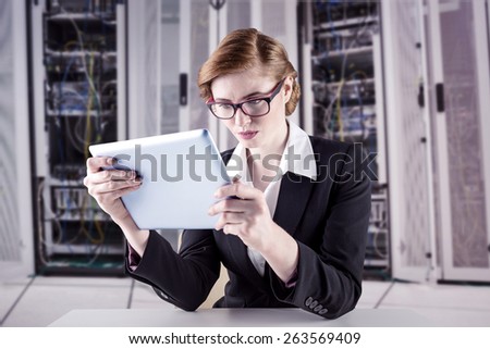 Redhead businesswoman using her tablet pc against data center