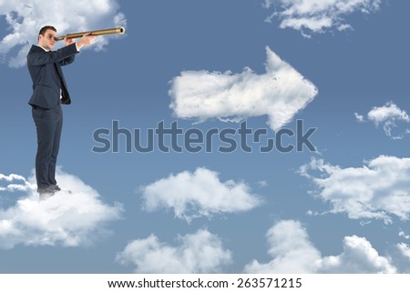 Businessman looking through telescope against cloud arrow