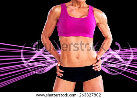 Female bodybuilder posing with hands on hips mid section against purple design