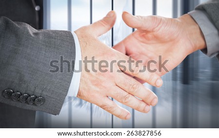 Two people going to shake their hands against room with large window looking on city