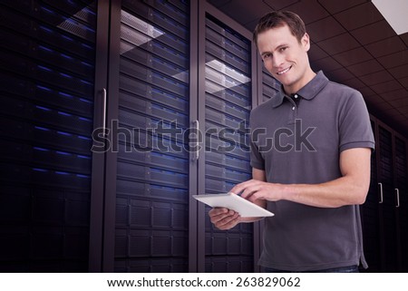 Smiling young man with tablet computer against digitally generated server room with towers