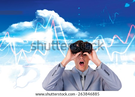 Suprised businessman looking through binoculars against bright blue sky with clouds