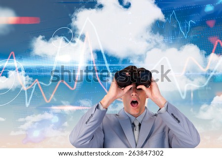 Suprised businessman looking through binoculars against stocks and shares on black background