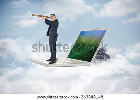 Businessman looking through telescope against mountain peak through the clouds