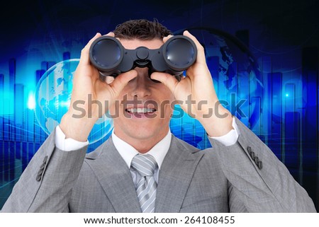 Businessman holding binoculars against global business graphic in blue