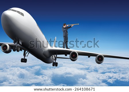 Businessman looking through telescope against blue sky over clouds at high altitude