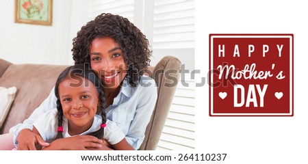 mothers day greeting against pretty mother sitting on the couch with her daughter smiling at camera