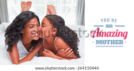 mothers day greeting against pretty woman lying on bed with her daughter kissing cheek