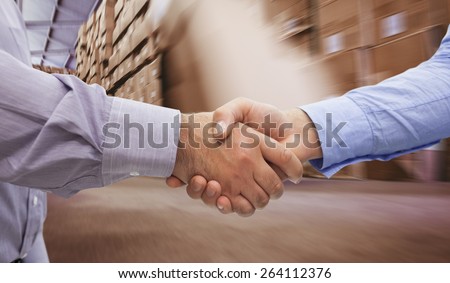 Men shaking hands against worker with fork pallet truck stacker in warehouse