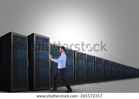 Focused businessman standing and pushing with hands against server tower