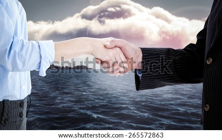 Close up of a business people closing a deal against calm sea with lighthouse