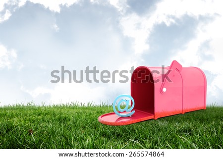 Red email post box against field and sky