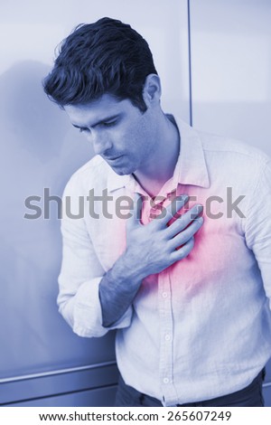 Casual young man with chest pain standing at home