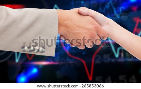 Close up of female and male hand shaking against stocks and shares on black background