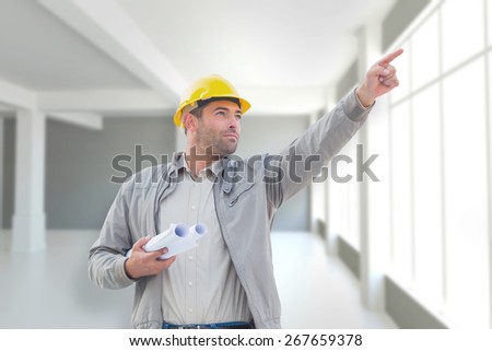 Architect pointing against modern white room with window