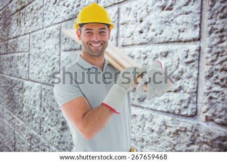 Happy carpenter against grey brick wall