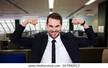 Happy businessman in suit cheering against empty office with separate units