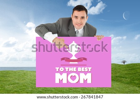 Businessman pointing at sign under him against field and sky