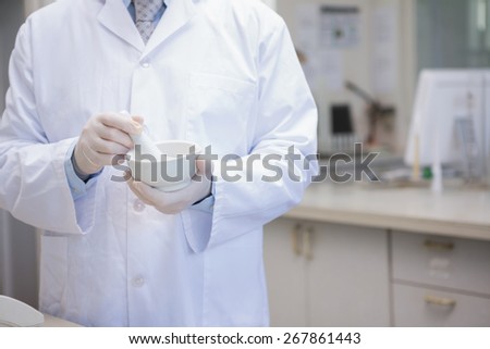 Scientist grinding powder with mortar in the laboratory