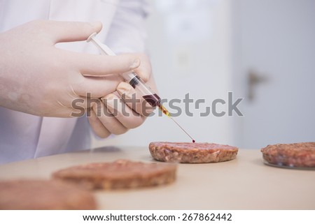 Scientist injecting beefsteaks in the laboratory