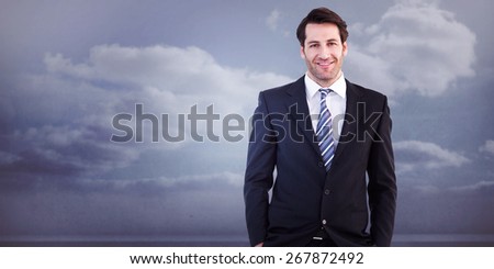 Smiling businessman standing with hands in pockets against clouds in a room
