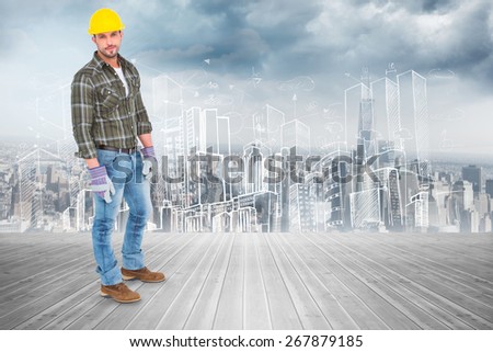 Full length portrait of confident handyman against room with large window looking on city