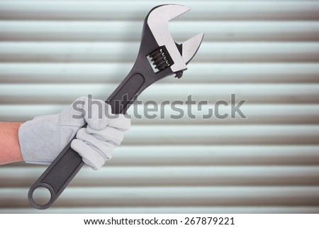 Mechanic holding spanners on white background against grey shutters