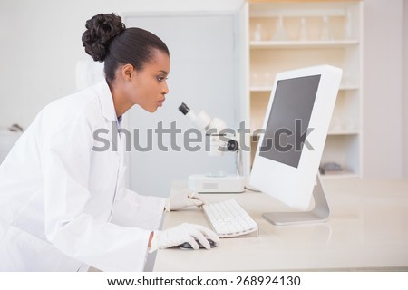 Concentrated scientist working with computer in laboratory