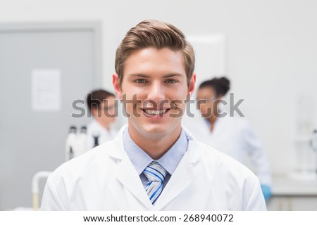 Happy scientist smiling at camera in the laboratory