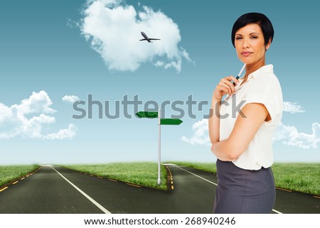 Thoughtful businesswoman against road leading out to the horizon