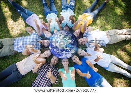 earth against happy friends in the park lying in circle