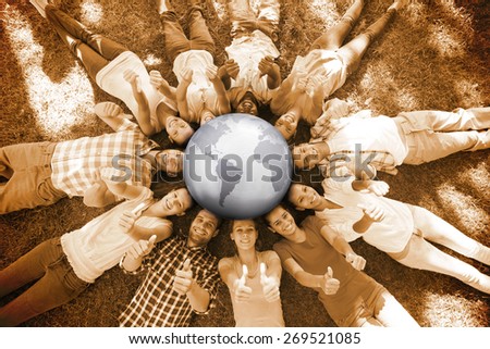 Silver earth against happy friends in the park lying in circle