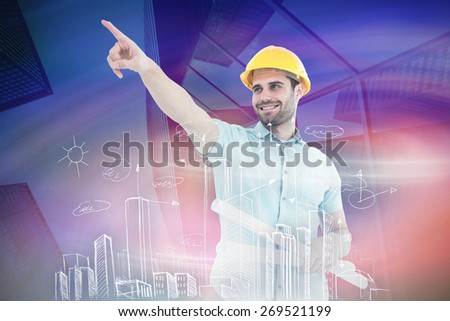 Male architect with blueprints pointing away against skyscraper