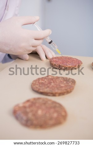 Scientist injecting beefsteaks in the laboratory
