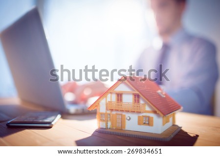 Estate agent using laptop at desk shot in studio