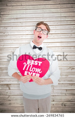 Geeky hipster holding heart card against wooden planks background