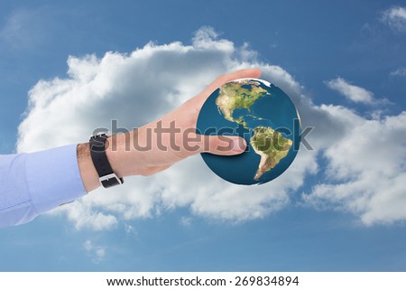Businessman showing with his hand against cloudy sky