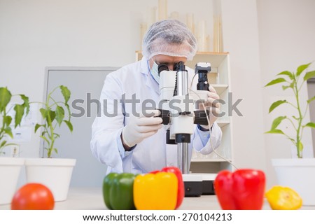 Food scientist looking through a microscope in laboratory
