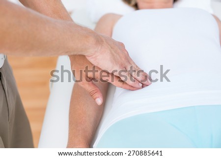 Physiotherapist examining his patients stomach in medical office