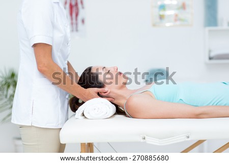 Physiotherapist doing neck massage in medical office