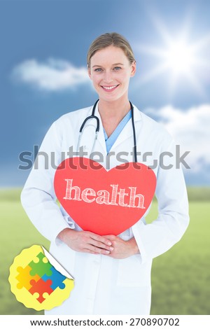 The word health and doctor holding red heart card against sunny green landscape