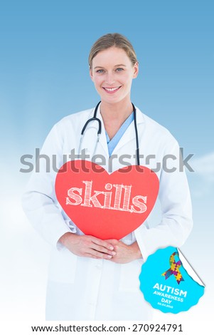 The word skills and doctor holding red heart card against blue sky