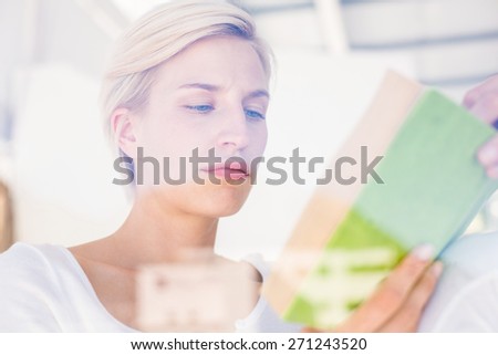 Thoughtful blonde woman reading a book in the bedroom