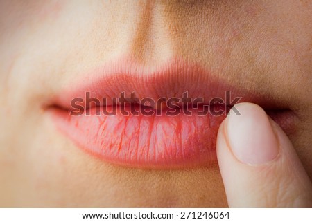 Woman pointing to her lips in close up